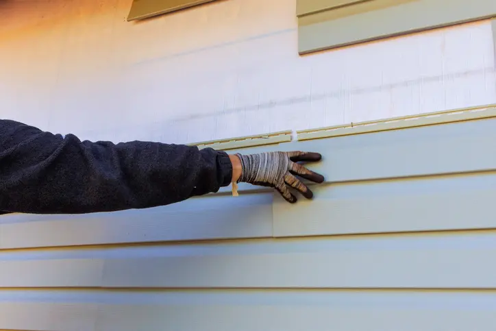 Damaged plastic siding is replaced as part of exterior house remodel
