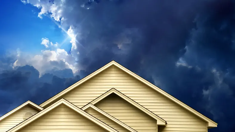 Close up rooftop of wooden house over over stormy sky